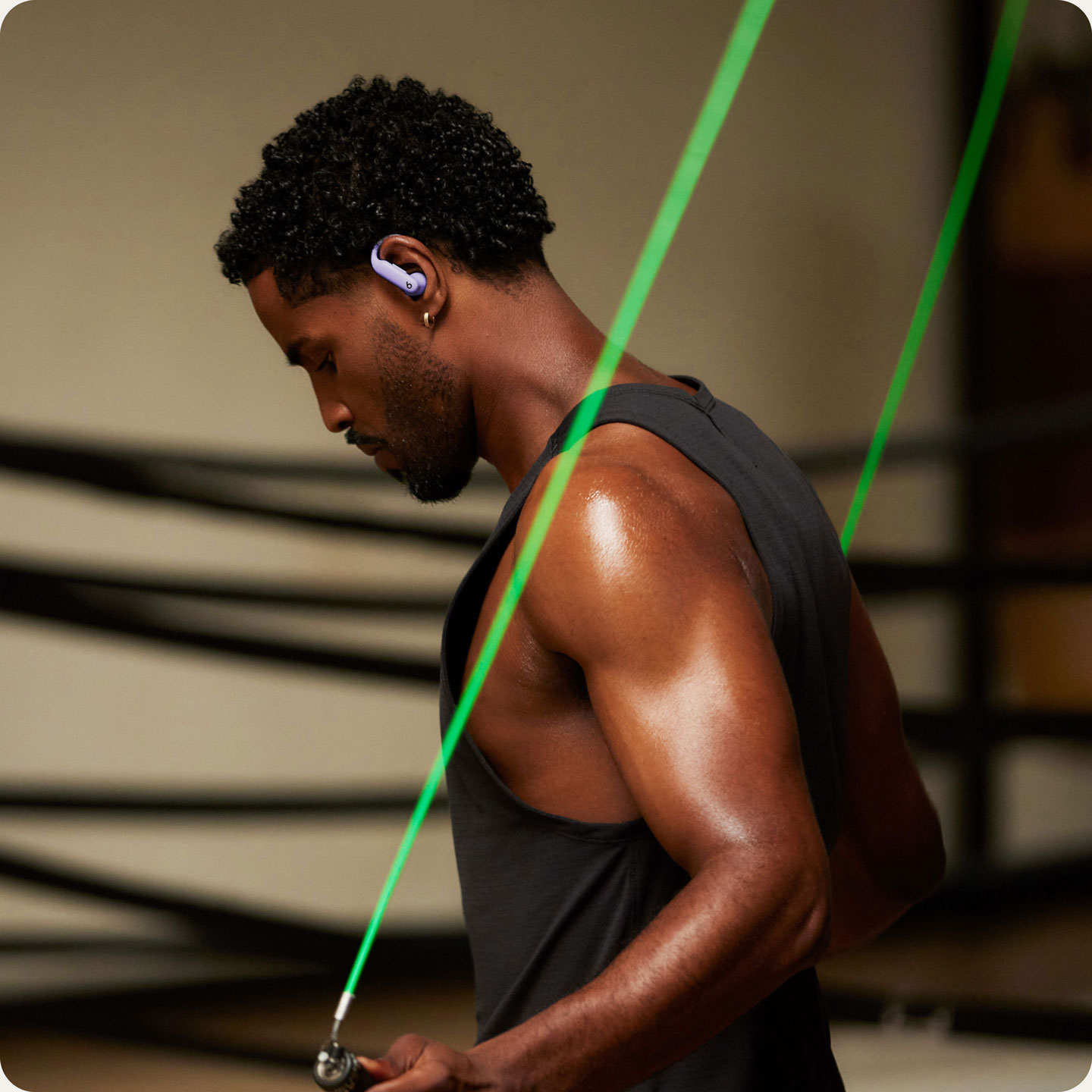 Person wearing Powerbeats Pro 2 earbuds while exercising with a skipping rope