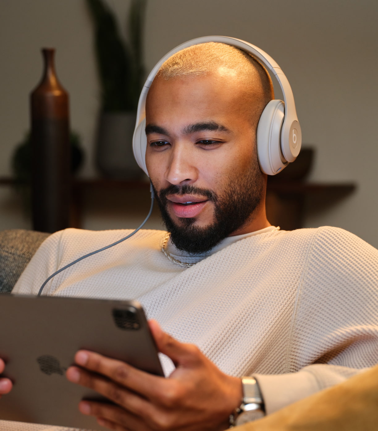 Personne portant un casque d'écoute Beats Studio Pro sans fil de couleur grès